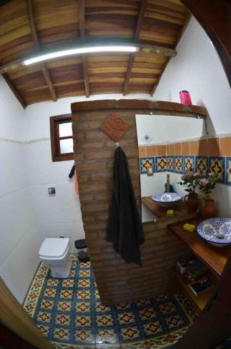 a small bathroom with a toilet and a mirror at Casinha das bananeiras in Delfinópolis