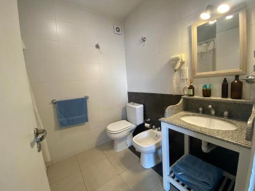 Un baño con inodoro, lavabo y espejo. en En el Corazón de Salta, en Salta