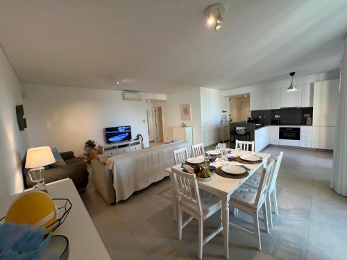 a living room and kitchen with a table and chairs at Gardens Side By FHR piscina, parking in Quarteira