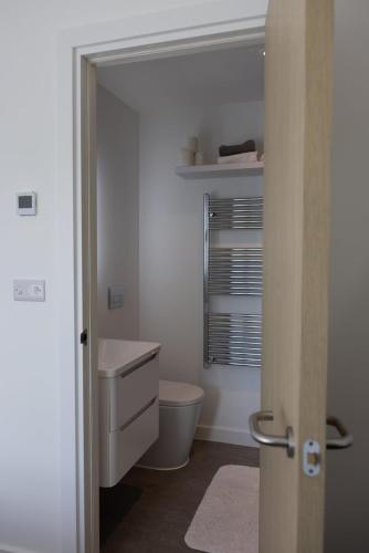 a white bathroom with a toilet and a sink at Cozy City Stay 2BR with Sofa Bed in Exmouth