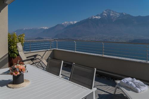 a balcony with a table and chairs and mountains at Valarin Luxury Apartments & Wellness, Vercana by Rent All Como in Vercana