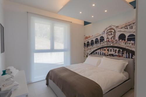 a bedroom with a bed with a painting on the wall at Valarin Luxury Apartments & Wellness, Vercana by Rent All Como in Vercana