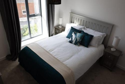 a bedroom with a white bed with pillows and a window at Cozy City Stay 2BR with Sofa Bed in Exmouth