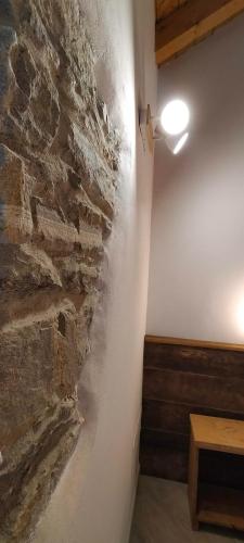 a room with a stone wall and a light on the wall at CA' DEL PITUR Apartments B&B Cicogna in Cicogna