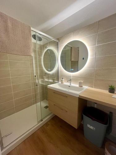 une salle de bain avec un lavabo et une douche avec un miroir dans l'établissement Serenity, appt avec loggia à 5min de la plage, à Courseulles-sur-Mer