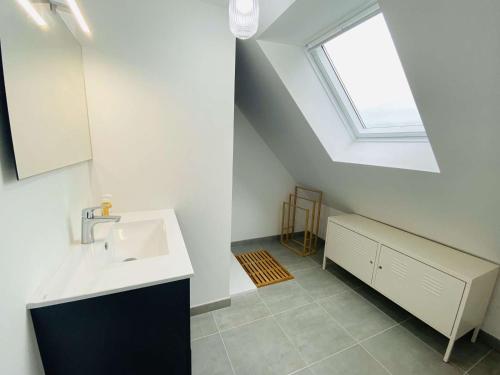 une salle de bain avec un lavabo et une fenêtre dans l'établissement Maison à 320m de la plage avec jardin à Trégastel - FR-1-368-459, à Trégastel