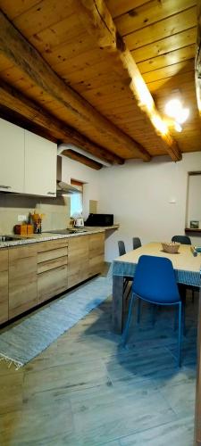 a kitchen with a table and a blue chair at CA' DEL PITUR Apartments B&B Cicogna in Cicogna