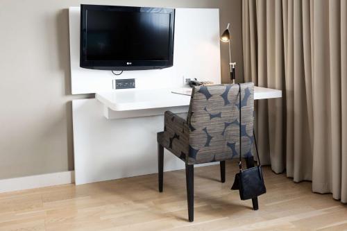 a room with a desk with a tv and a chair at Scandic Julia in Turku