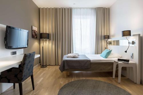 a hotel room with a bed and a tv at Scandic Julia in Turku