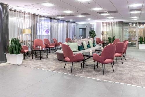 a waiting room with chairs and tables in a lobby at Scandic Julia in Turku