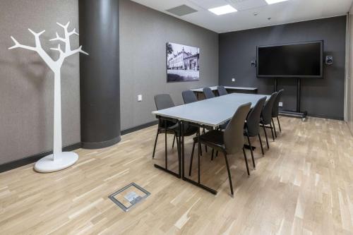 a conference room with a table and chairs and a tv at Scandic Julia in Turku