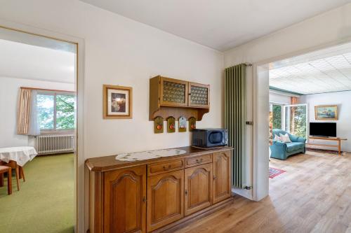 a kitchen with a microwave and a living room at Gästehaus Hirzel in Bad Wildbad