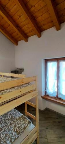 a room with two bunk beds and a window at CA' DEL PITUR Apartments B&B Cicogna in Cicogna