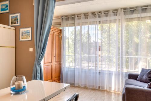 a living room with a couch and a large window at Les saules in Le Grau-dʼAgde