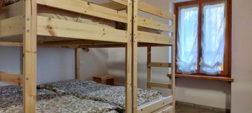 a bunk bed room with two beds and a window at CA' DEL PITUR Apartments B&B Cicogna in Cicogna
