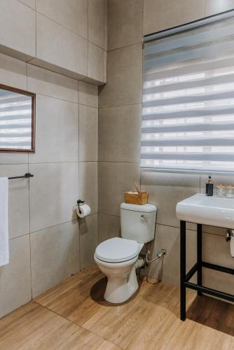 a bathroom with a white toilet and a sink at Serene Guesthouse in Middelburg