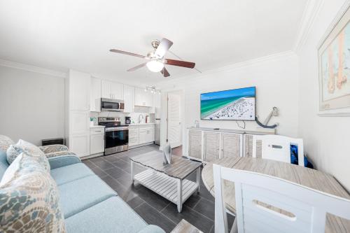 a living room with a blue couch and a ceiling fan at Gulf Holiday By Beachside Management in Siesta Key