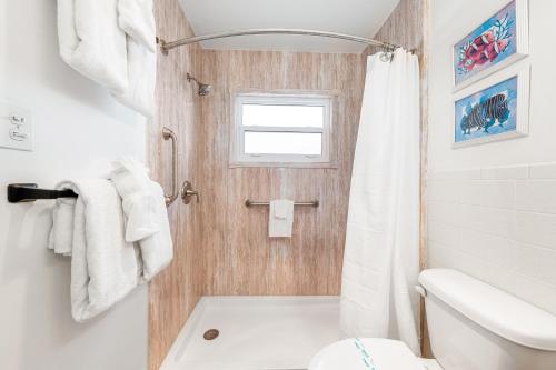 a white bathroom with a toilet and a shower at Gulf Holiday By Beachside Management in Siesta Key