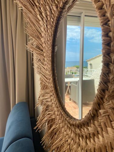 a mirror in a living room with a view of the ocean at Les Alcyons in Le Lavandou