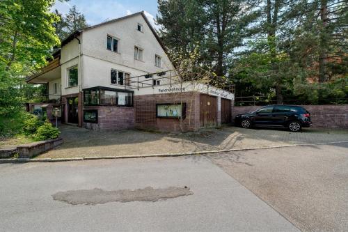 a house with a car parked in front of it at Gästehaus Hirzel in Bad Wildbad