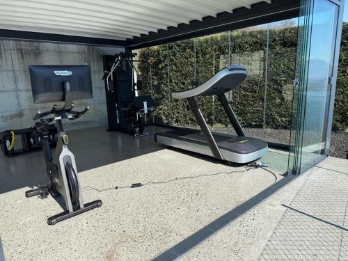 a gym with a treadmill and a tv in a room at Valarin Luxury Apartments & Wellness, Vercana by Rent All Como in Vercana