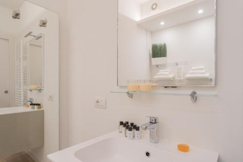 a white bathroom with a sink and a mirror at Valarin Luxury Apartments & Wellness, Vercana by Rent All Como in Vercana