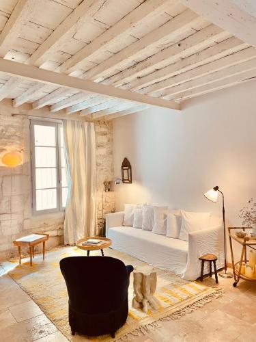 un salon avec un canapé blanc et une table dans l'établissement La maison de limpasse Arles Arènes, à Arles