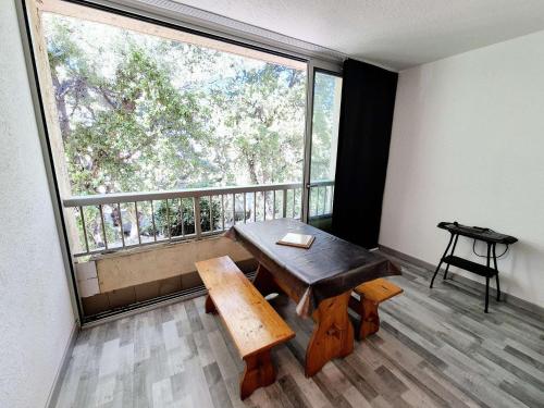 une pièce avec une table et une grande fenêtre dans l'établissement Charmant studio, 4 couchages, lumineux, 500 m de la plage et des commerces..., à Saint-Elme