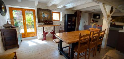 a dining room with a wooden table and chairs at Gîte Les Pierres Blondes in Groléjac