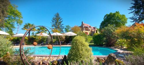 a swimming pool in a yard with a house at Gîte Les Pierres Blondes in Groléjac