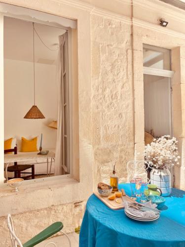 une table bleue avec de la nourriture dans une pièce dans l'établissement L'impasse Maison arènes arles, à Arles