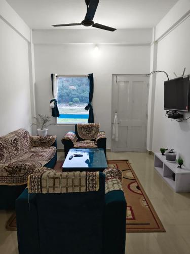 a living room with two couches and a tv at Valley View Homestay in Dirang Dzong