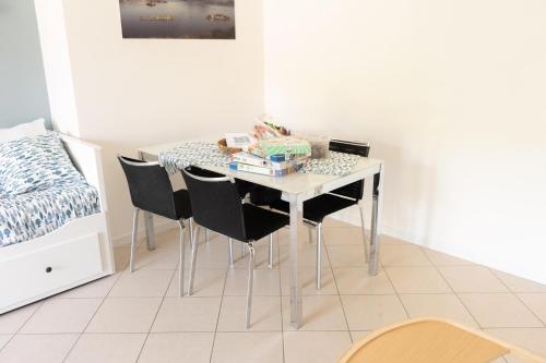 a dining room table with black chairs in a room at CasaGiaco Verbania in Intra