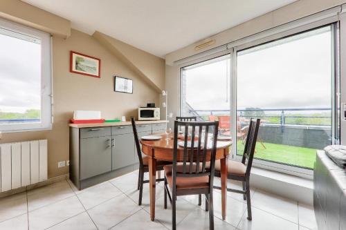 a kitchen and dining room with a table and chairs at Appartement pour 4 avec grand balcon in Sarzeau