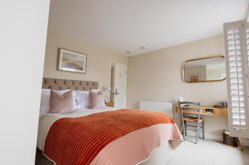 a bedroom with a bed with an orange blanket at White Hart Inn in Brightling