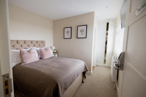 a bedroom with a bed with pink pillows on it at White Hart Inn in Brightling