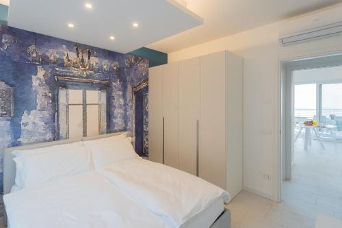 a bedroom with a white bed and a blue wall at Valarin Luxury Apartments & Wellness, Vercana by Rent All Como in Vercana