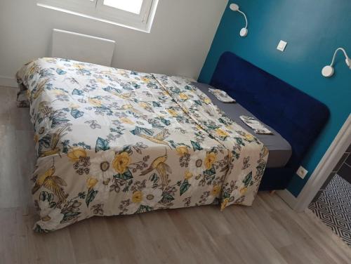 une chambre avec un lit avec un couvre-lit fleuri dans l'établissement Le CosyNew 3, à Calais