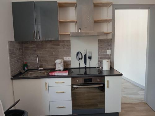 une cuisine avec un évier et un plan de travail dans l'établissement Le CosyNew 3, à Calais