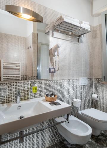 a bathroom with a sink and a toilet and a mirror at Residence Marzia in Rimini
