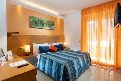 a bedroom with a bed and a desk with a computer at Residence Marzia in Rimini