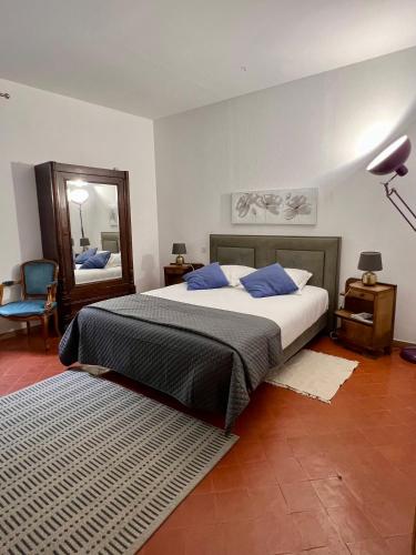 a bedroom with a large bed and a mirror at Entre Midi - Maison d'Hôtes - B&B in Capestang