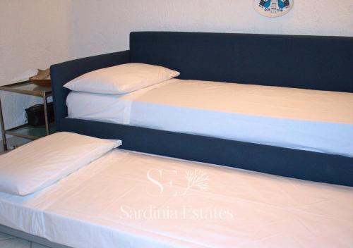 two beds sitting next to each other in a room at Rainbow House - Fronte Spiaggia in Porto Rotondo