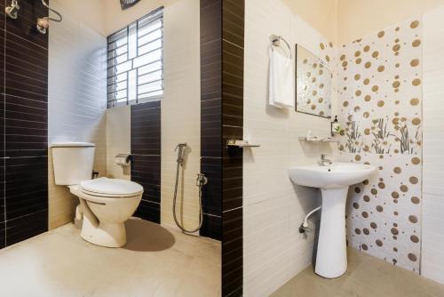a bathroom with a toilet and a sink at Treebo Urban Oasis Inn, Sixmile in Guwahati