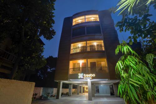 a tall building with a sign in front of it at Treebo Urban Oasis Inn, Sixmile in Guwahati