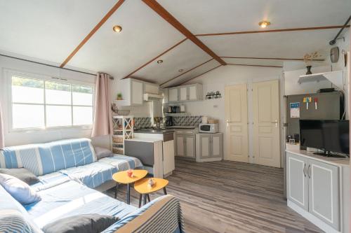 un salon avec un canapé bleu et une cuisine dans l'établissement Mh 229 La Tremblade, à La Tremblade