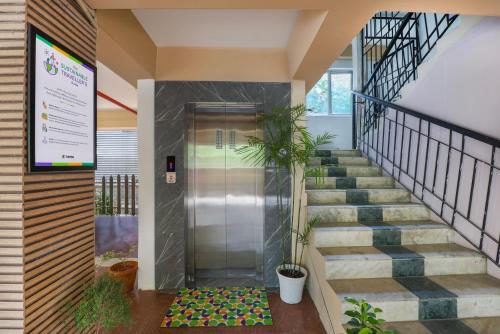 an elevator in a building with stairs and plants at Treebo Urban Oasis Inn, Sixmile in Guwahati