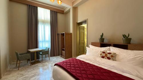 a bedroom with a large bed with a red blanket at Hotel Lost Ashrafieh in Beirut