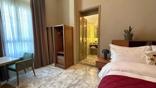 a bedroom with a bed and a desk and a mirror at Hotel Lost Ashrafieh in Beirut