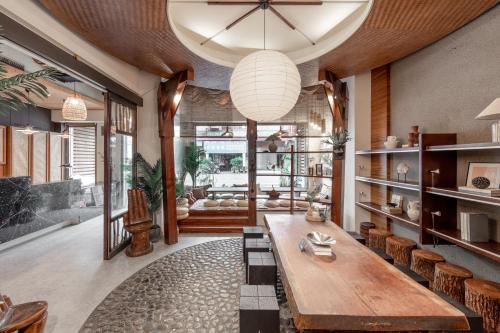 a living room with a large wooden table and chairs at Sun Moon Lake ItaThao Vacation Inn with Elevator in Yuchi
